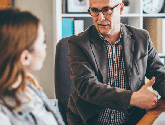 Two people talking sat down at a table