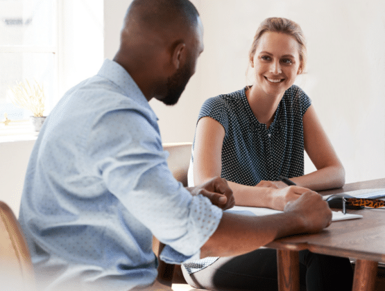Two people sitting at a table in a work meeting