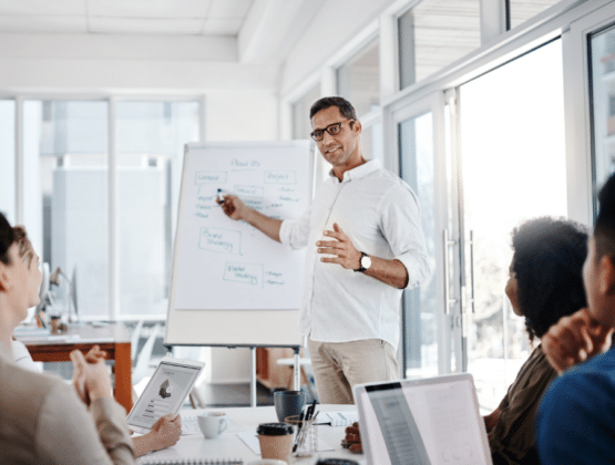 A person standing in front of a whiteboard in a meeting