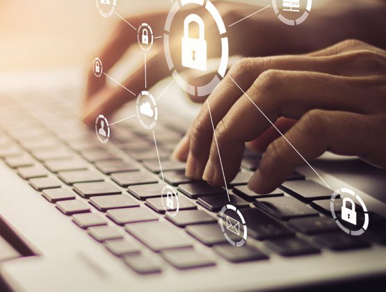 Person using laptop with floating cyber security icons