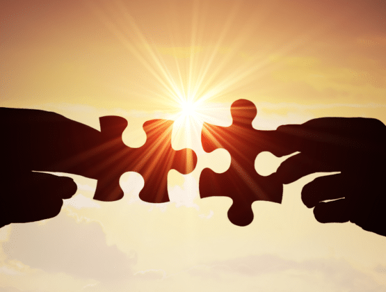 A couple of hands holding two puzzle pieces