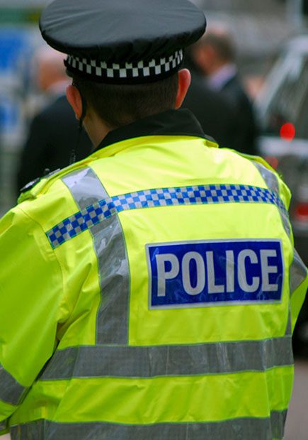 Police officer in uniform with their back to the camera.