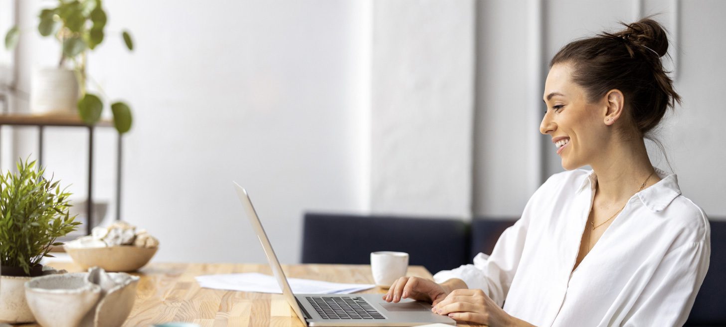 Person smiling while working on a laptop