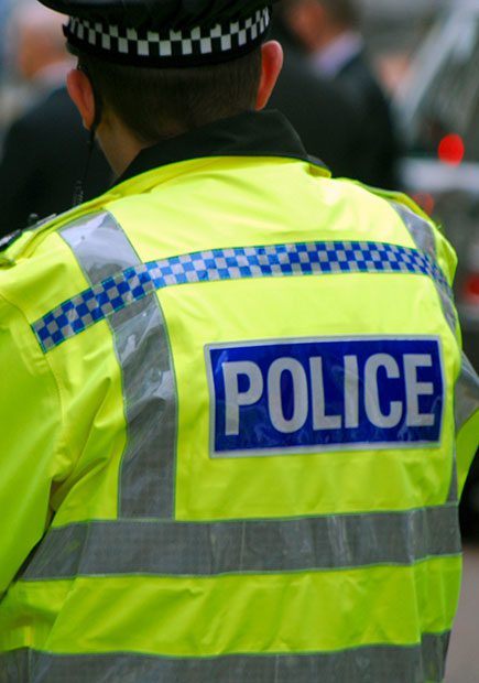 Police officer in uniform with back to camera