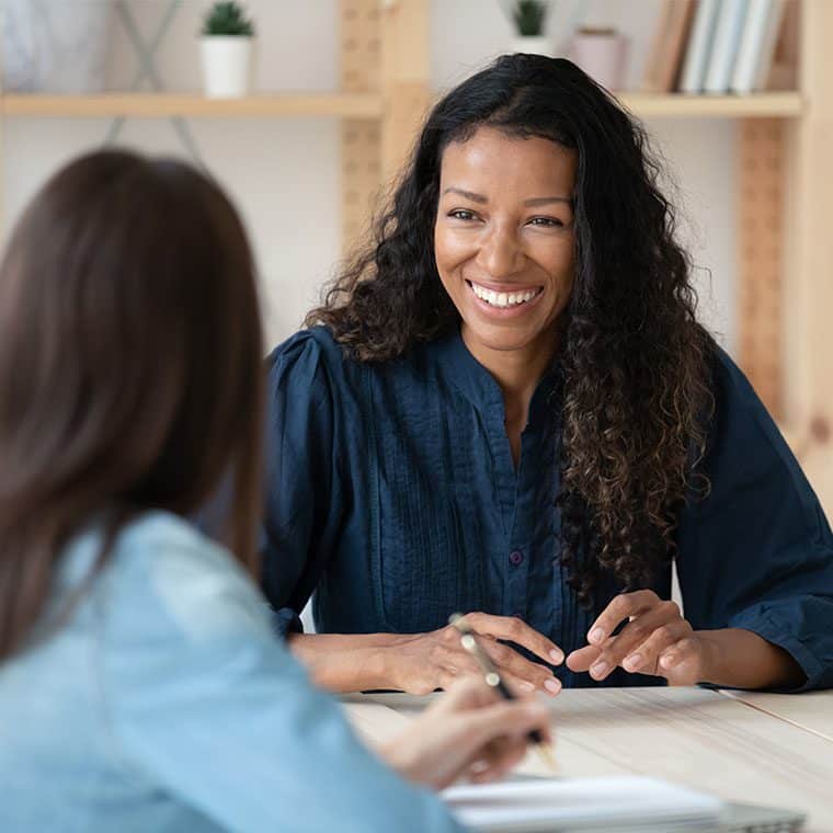 One woman coaching another in a meeting