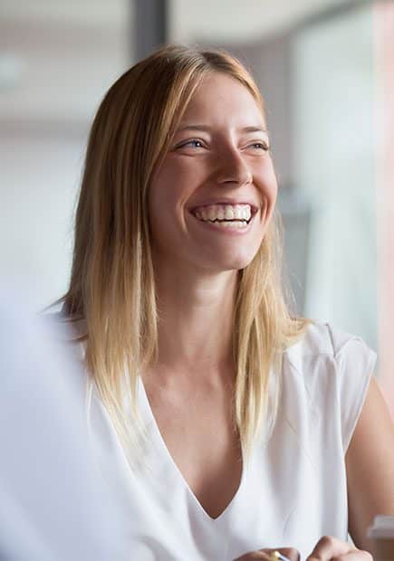Woman in office meeting smiling at colleagues