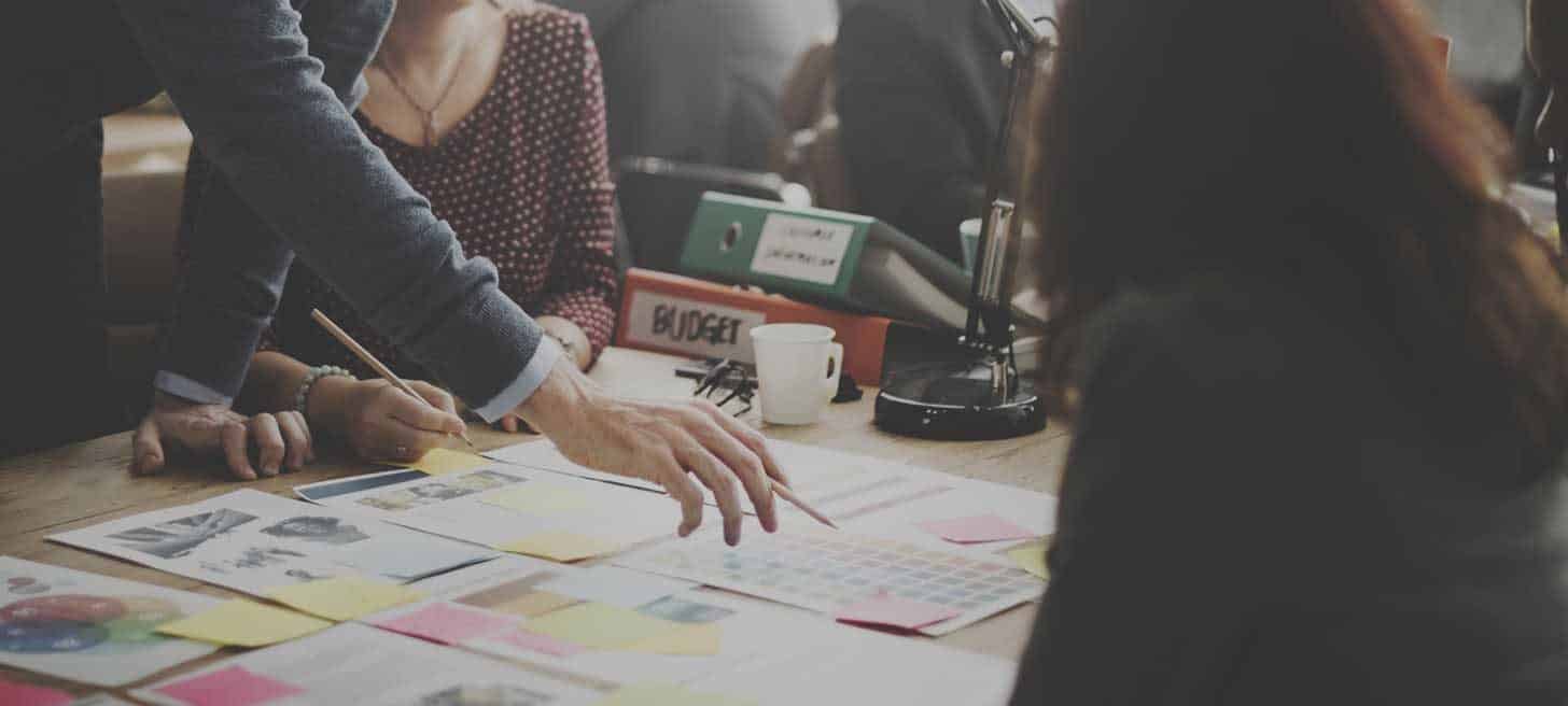 Group of people in an office looking over some documents on a desk