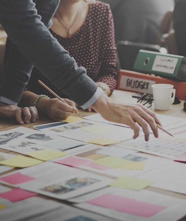 Group of people in an office looking over some documents on a desk