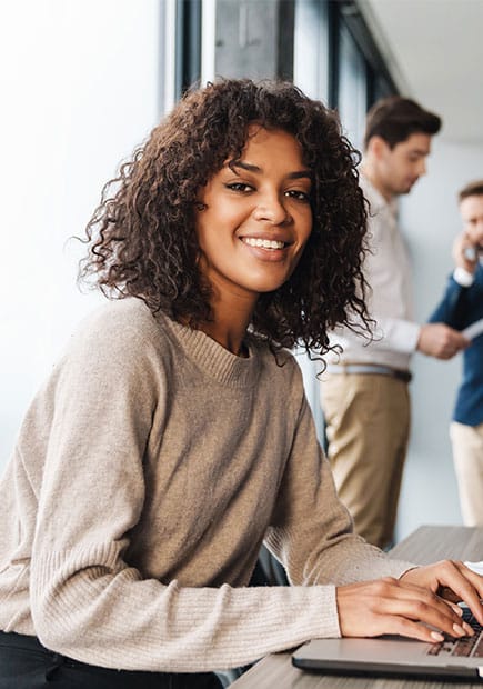 Woman working in office setting smiling at the camera