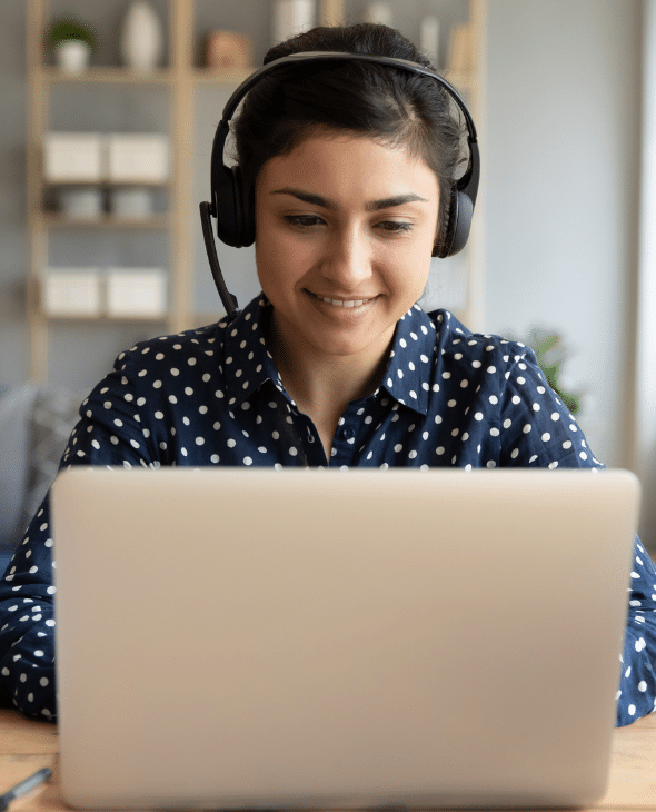 Woman watching a webinar on a laptop with headphones on.