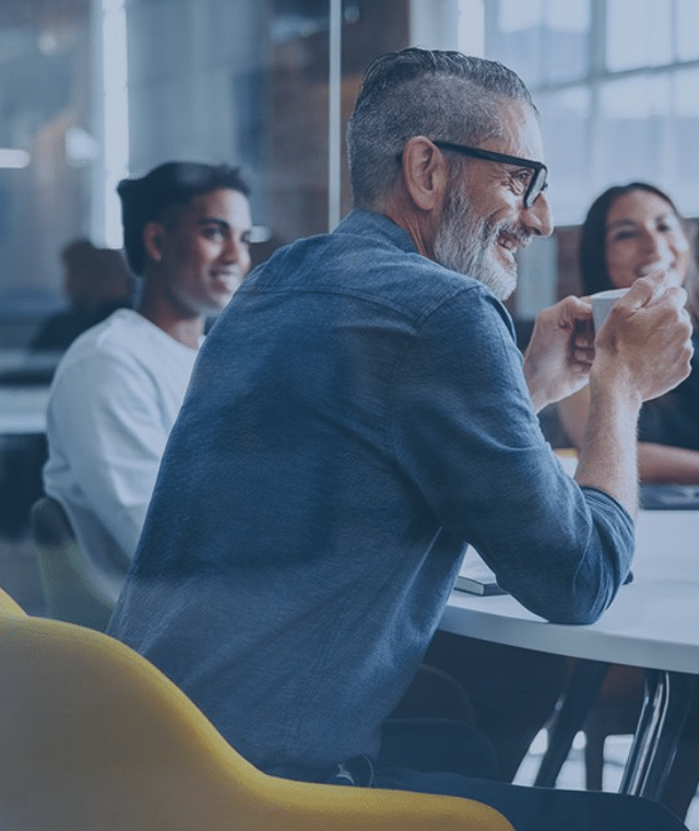 Colleagues smiling in a meeting room in an office