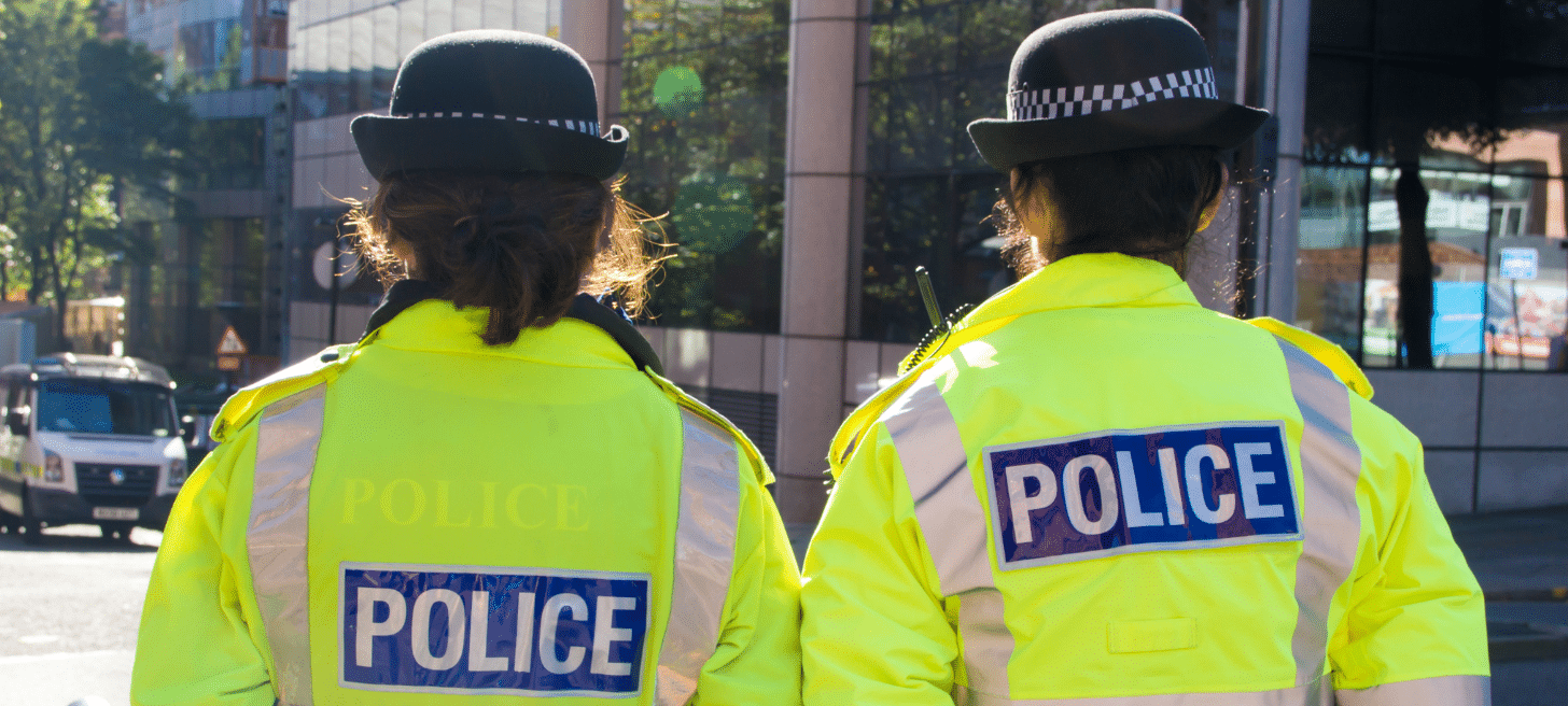Back of two police officers walking in street