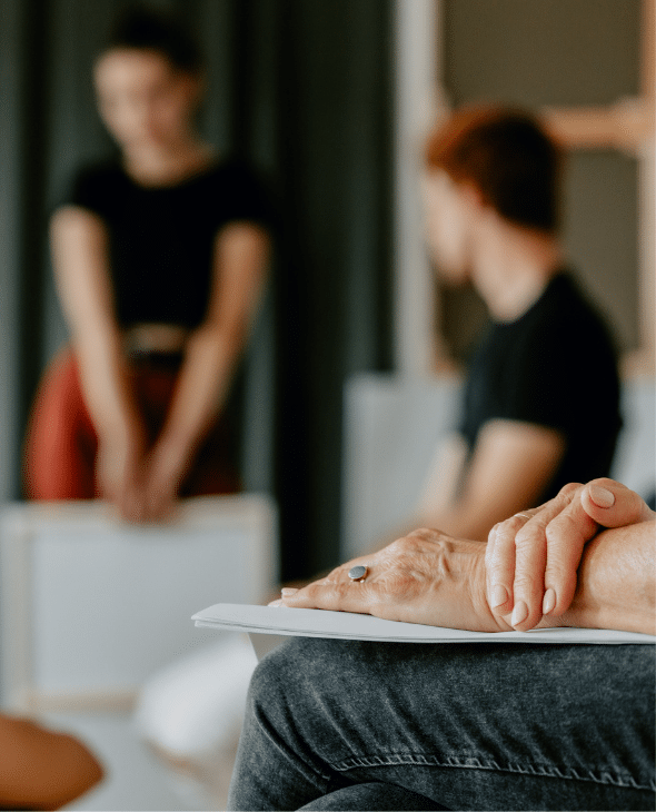 A person's hand on a piece of paper in a meeting