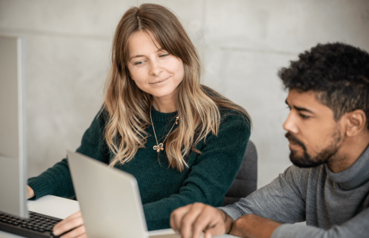 Two people working together looking at a computer screen