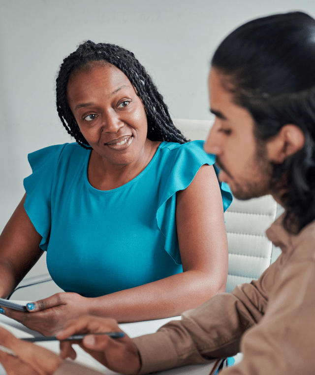 Two people talking together in an office environment.