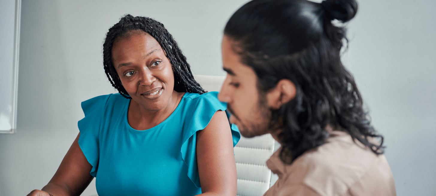 Two people talking together in an office environment.