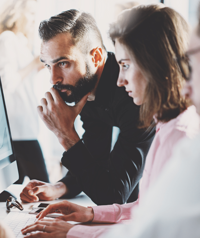 Three people looking at a computer screen together