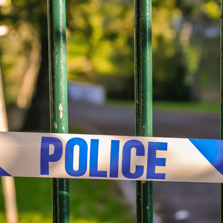 Police tape across a park fence