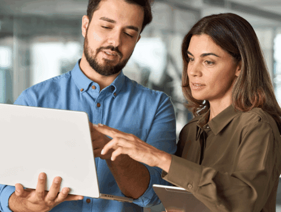 Two colleagues looking at a laptop together