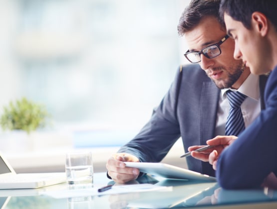 Two office colleagues discussing something at a desk