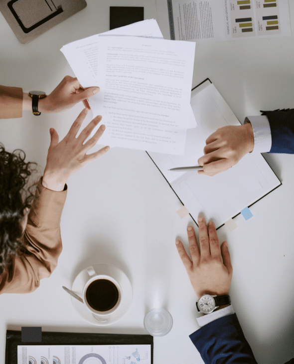 aerial shot of office desk with two people reviewing a document together