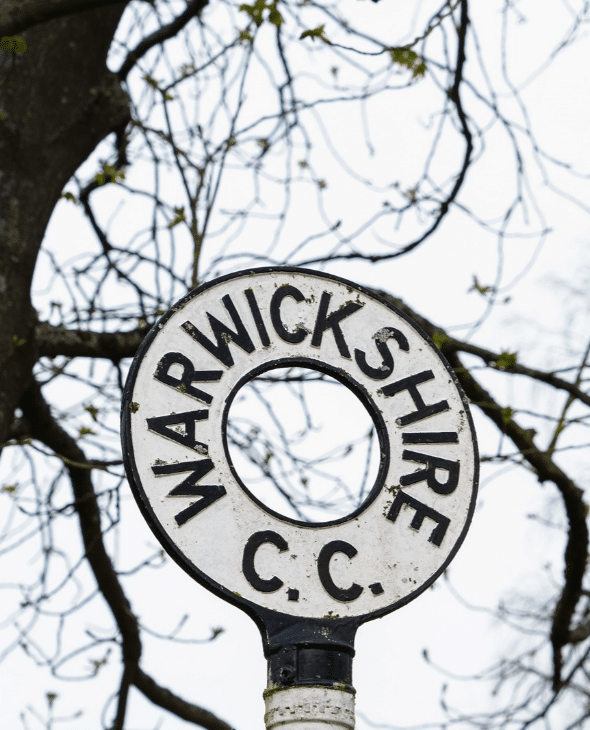 Warwickshire County Council sign on roadside in rural England