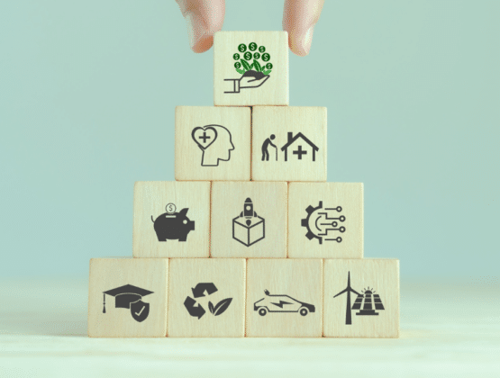 A hand placing blocks on a pyramid