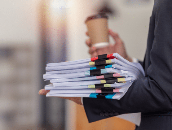 A person holding a stack of files