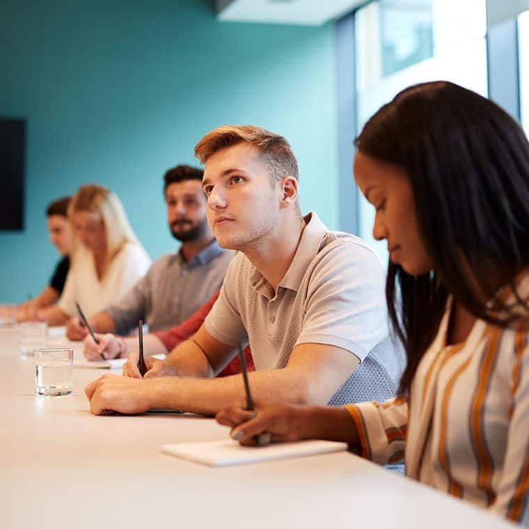 Group of apprentices in a classroom making notes