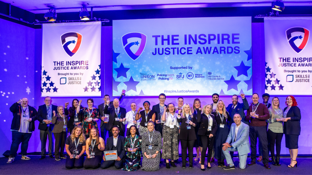 2023 Inspire Justice Award winners at the ceremony, on the stage together showing their trophies.