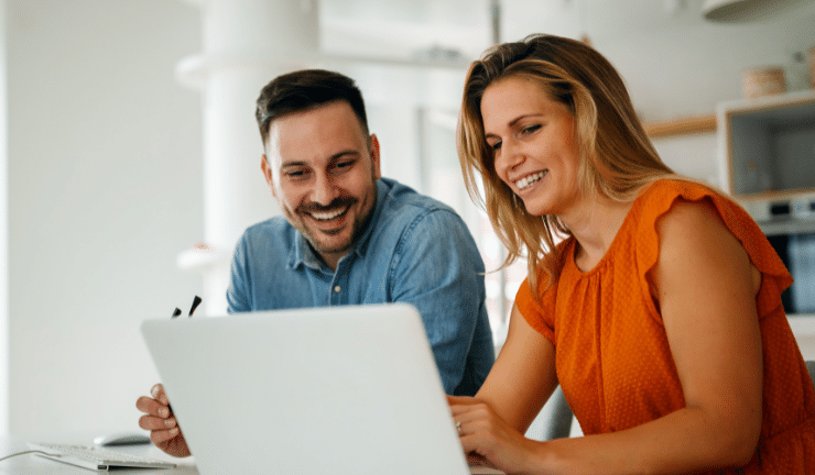 Two colleagues looking at a laptop screen together